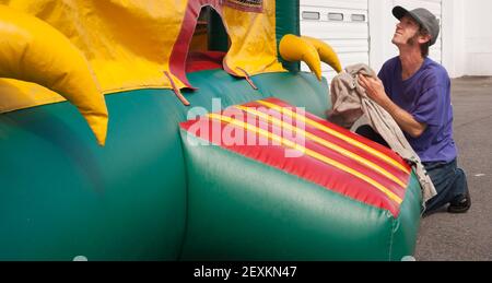 Mann Reinigt Party Platz Ausrüstung Verleih Spaß Bouncy Ballon Stockfoto