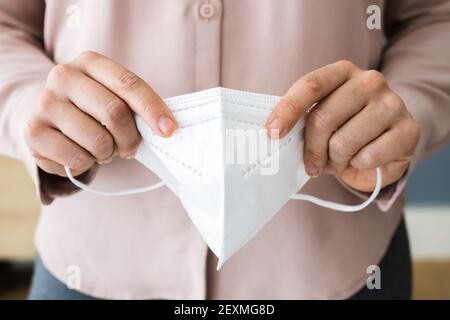 Frau, die eine medizinische FFP2 Gesichtsmaske aufsetzt Stockfoto