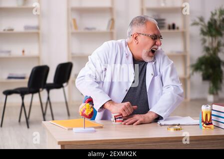 Alte Zahnarztlehrerin sitzt im Klassenzimmer Stockfoto