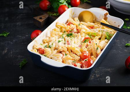 Fetapasta. Trending viralen Feta backen Pasta Rezept aus Kirschtomaten, Feta-Käse, Knoblauch und Kräuter in einer Auflaufform. Stockfoto