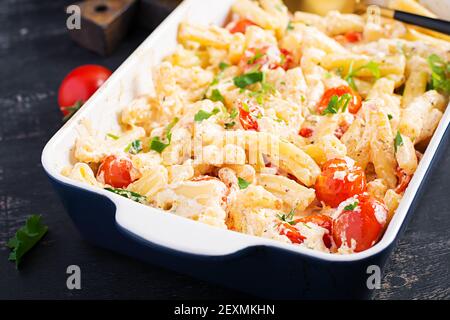 Fetapasta. Trending viralen Feta backen Pasta Rezept aus Kirschtomaten, Feta-Käse, Knoblauch und Kräuter in einer Auflaufform. Stockfoto
