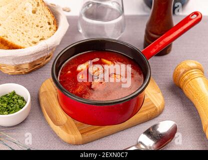 Traditionelle ungarische warme Gulaschsuppe mit gebratenen Würstchen auf Restauranttisch Stockfoto