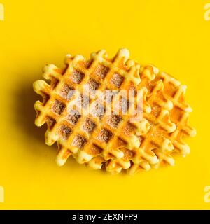 Draufsicht, drei Zucker belgium Waffeln auf gelbem Hintergrund.Süßes Dessert. Stockfoto