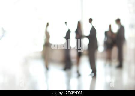Verschwommenes Bild einer Gruppe von Geschäftsleuten, die in der Bürolobby stehen. Stockfoto