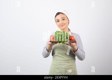 Bild von einer schönen attraktiven Frau mit einem Holzbrett Mit Petersilie Stockfoto