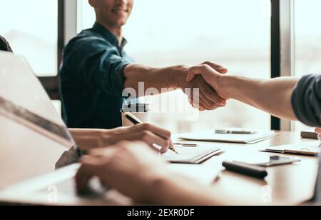 Nahaufnahme. Junge Geschäftsleute, die einen neuen Vertrag eingehen. Stockfoto