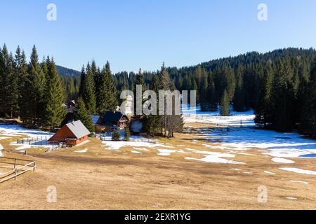 Wald Winterlandschaft mit kleinen Häusern in europäischen Alpen. Stockfoto