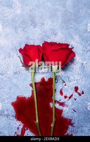 Rote Rosen und Blut auf einem blauen texturierten Hintergrund mit Platz für Text und Text Stockfoto