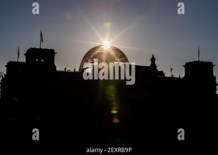 Berlin, Deutschland. März 2021, 05th. Die Sonne geht hinter der Kuppel des Reichstagsgebäudes auf. Quelle: Christoph Soeder/dpa/Alamy Live News Stockfoto