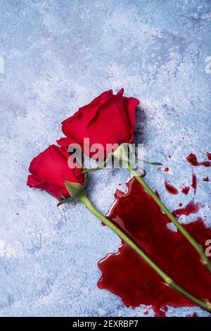 Rote Rosen und Blut auf einem blauen texturierten Hintergrund mit Platz für Text und Text Stockfoto