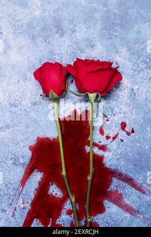 Rote Rosen und Blut auf einem blauen texturierten Hintergrund mit Platz für Text und Text Stockfoto
