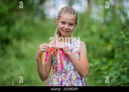 Teenager-Mädchen mit bunten Dreadlocks im Wald. Stockfoto