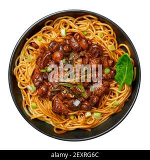 Bakmi oder Mie Ayam in schwarzer Schale isoliert auf weiß. Indonesische Küche Nudeln Fleischgericht. Traditionelles asiatisches Essen und Essen. Draufsicht Stockfoto