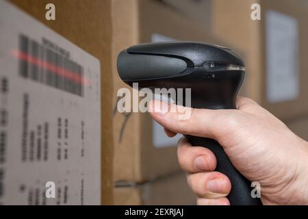 Scannen von Barcodes mit Barcodeleser auf Verpackungen im Lager. Stockfoto