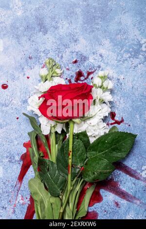 Rote Rosen und Blut auf einem blauen texturierten Hintergrund mit Platz für Text und Text Stockfoto