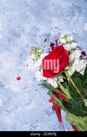 Rote Rosen und Blut auf einem blauen texturierten Hintergrund mit Platz für Text und Text Stockfoto