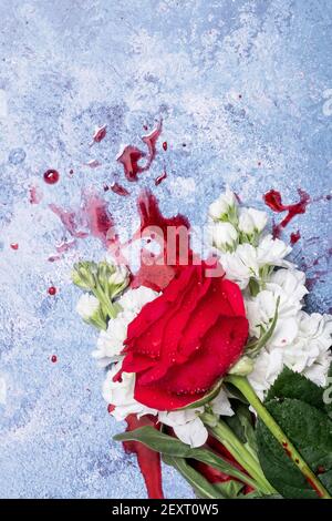 Rote Rosen und Blut auf einem blauen texturierten Hintergrund mit Platz für Text und Text Stockfoto