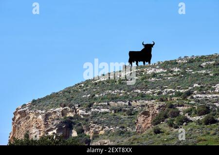 Ein Blick auf den berühmten Osborne-Stier auf einem Hügel in Almayate, Spanien gegen einen klaren blauen Himmel Stockfoto