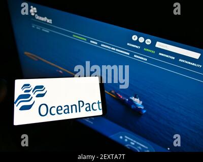 Person, die Smartphone mit Logo der brasilianischen Firma OceanPACT Serviços Marítimos S.A. auf dem Bildschirm vor der Website hält. Konzentrieren Sie sich auf die Telefonanzeige. Stockfoto