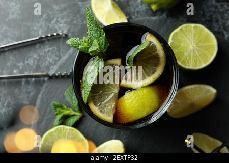 Tablett mit Cuba Libre Cocktail und verschwommene Lichter auf schwarz Rauchige Hintergrundfarbe Stockfoto