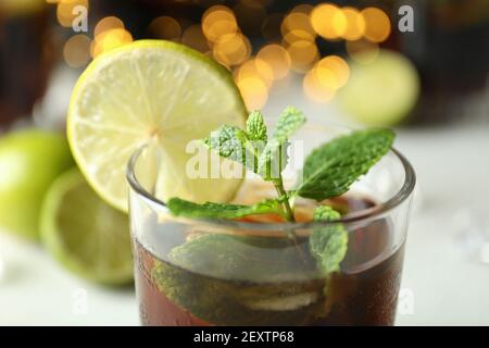 Glas Cuba Libre gegen verschwommenes Licht, Nahaufnahme Stockfoto