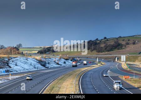 Verkehr auf der Autobahn M6 in Shap in Cumbria an einem Winterabend. Stockfoto