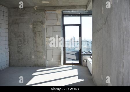 Innenansicht einer leeren, neu errichteten Wohnung, Wohnung ohne Reparatur mit Fenster in einem neu erbauten, errichteten Wohngebäude. Stockfoto
