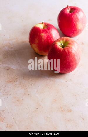 Drei rosa Lady Äpfel auf einem rosa Marmor Hintergrund. Stockfoto