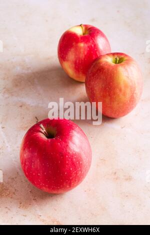 Drei rosa Lady Äpfel auf einem rosa Marmor Hintergrund. Stockfoto