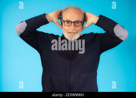 Staunend älterer Mann in legerer Pullover isoliert auf blauem Hintergrund Stockfoto