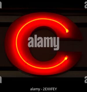 Rot glühender Neonbuchstabe C in der Nacht Stockfoto