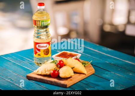 BRCKO, BOSNIEN UND HERZEGOWINA - 03. Jul 2019: Flasche Öl mit leckerem Essen auf dem Tisch im Garten Stockfoto