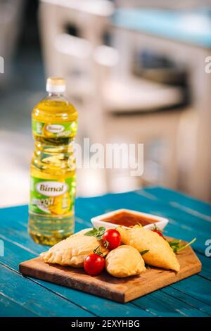 BRCKO, BOSNIEN UND HERZEGOWINA - 03. Jul 2019: Flasche Öl mit leckerem Essen auf dem Tisch im Garten Stockfoto
