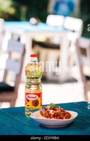 BRCKO, BOSNIEN UND HERZEGOWINA - 03. Jul 2019: Flasche Öl mit leckerem Essen auf dem Tisch im Garten Stockfoto