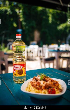 BRCKO, BOSNIEN UND HERZEGOWINA - 03. Jul 2019: Flasche Öl mit leckerem Essen auf dem Tisch im Garten Stockfoto