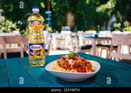 BRCKO, BOSNIEN UND HERZEGOWINA - 03. Jul 2019: Flasche Öl mit leckerem Essen auf dem Tisch im Garten Stockfoto