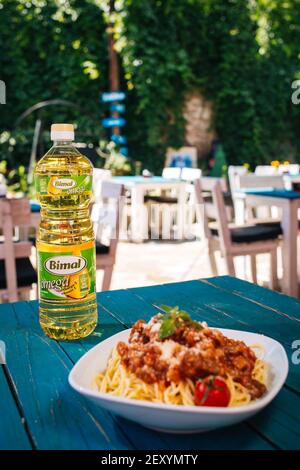 BRCKO, BOSNIEN UND HERZEGOWINA - 03. Jul 2019: Flasche Öl mit leckerem Essen auf dem Tisch im Garten Stockfoto