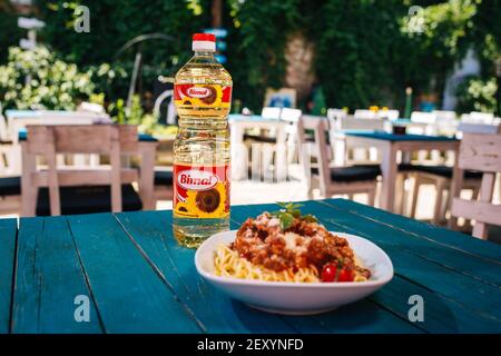 BRCKO, BOSNIEN UND HERZEGOWINA - 03. Jul 2019: Flasche Öl mit leckerem Essen auf dem Tisch im Garten Stockfoto