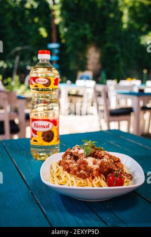 BRCKO, BOSNIEN UND HERZEGOWINA - 03. Jul 2019: Flasche Öl mit leckerem Essen auf dem Tisch im Garten Stockfoto