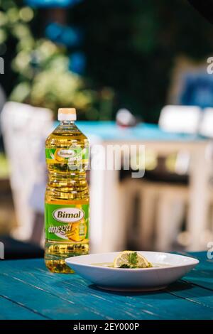 BRCKO, BOSNIEN UND HERZEGOWINA - 03. Jul 2019: Flasche Öl mit leckerem Essen auf dem Tisch im Garten Stockfoto