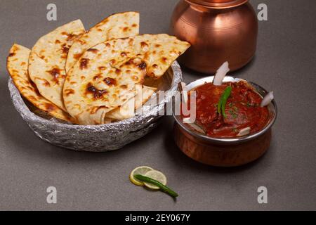 Paneer Butter Masala oder Cheese Cottage Curry, beliebtes indisches Mittag-/Abendessen mit Naan oder Roti auf launischem Hintergrund, selektiver Fokus Stockfoto