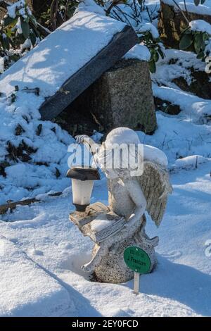 Sophien Pfarrfriedhof -Engel,mit Laterne und Buch über schneebedecktes Grab im Winter, Friedhof der Sophien Gemeinde, Mitte,Berlin,Deutschland Stockfoto