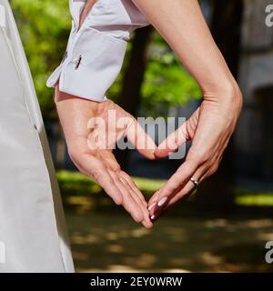 Hände Braut und Bräutigam in Form von Herzen Stockfoto