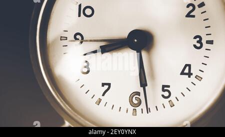 Die alte Uhr auf dem Zifferblatt zeigt halb acht Uhr morgens. Schnelle Zeit und die Vergangenheit. Erinnerungen. Stockfoto