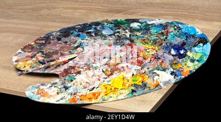 Helle Palette mit Farben und Pinsel auf dem Tisch, Nahaufnahme, Kopierraum. Stockfoto