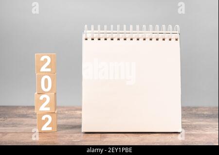 2022 Mockup-Notizblock. 2022 Würfel Holztisch Hintergrund. Neues Jahr. Pläne für 2022, Platz für Ihren Text auf dem Notizblock, Mockup Kalender Stockfoto