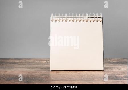 Mockup Notizblock. Unbeschriftete Spiral gebundene Notizblock Mockup mit auf hellgrauem Hintergrund und Holztisch. Vorlage für die Platzierung Ihres Designs. Stockfoto
