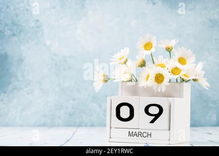 White Cube Kalender für märz mit Gänseblümchen über geschmückt Blauer Hintergrund mit Kopierbereich Stockfoto