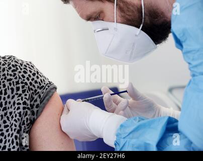 Alpen, Deutschland. März 2021, 05th. Ein Pädagoge wird von Krankenschwester Kevin Rheinfelder in der mobilen Impfeinheit mit dem AstraZeneca-Impfstoff geimpft. Durch die zentrale mobile Einheit kann nun eine größere Anzahl von Menschen aus dem ganzen Landkreis schneller geimpft werden. Quelle: Roland Weihrauch/dpa/Alamy Live News Stockfoto