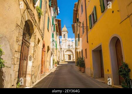 Eine Wohnstraße führt nach Collegiata dei Santi Quirico e Giulitta im mittelalterlichen Dorf San Quirico D'Orcia, Provinz Siena, Toskana, Italien Stockfoto